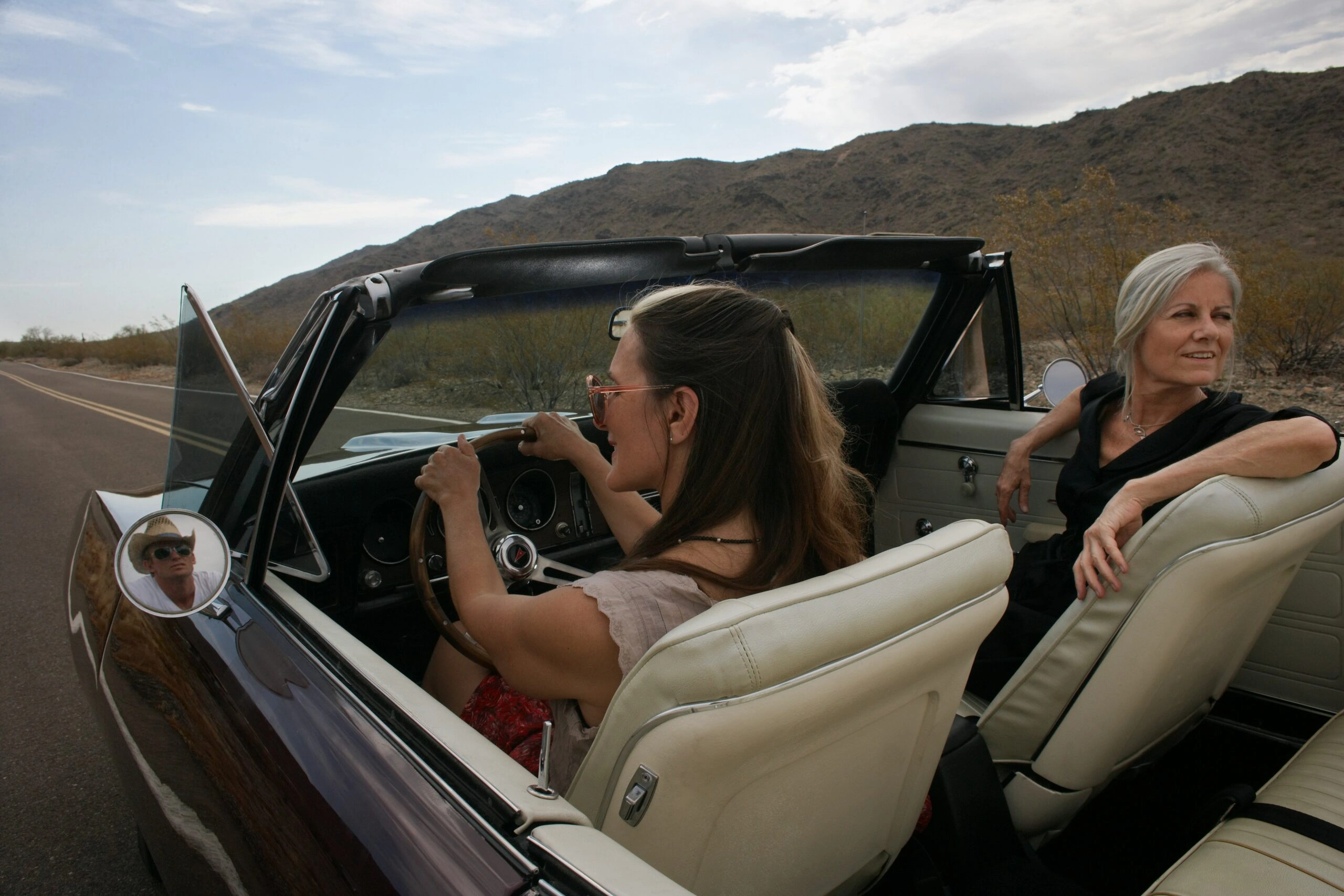 Two women on an open road in a convertible — accompanying the section on why building a custom GPT gives business owners a head start