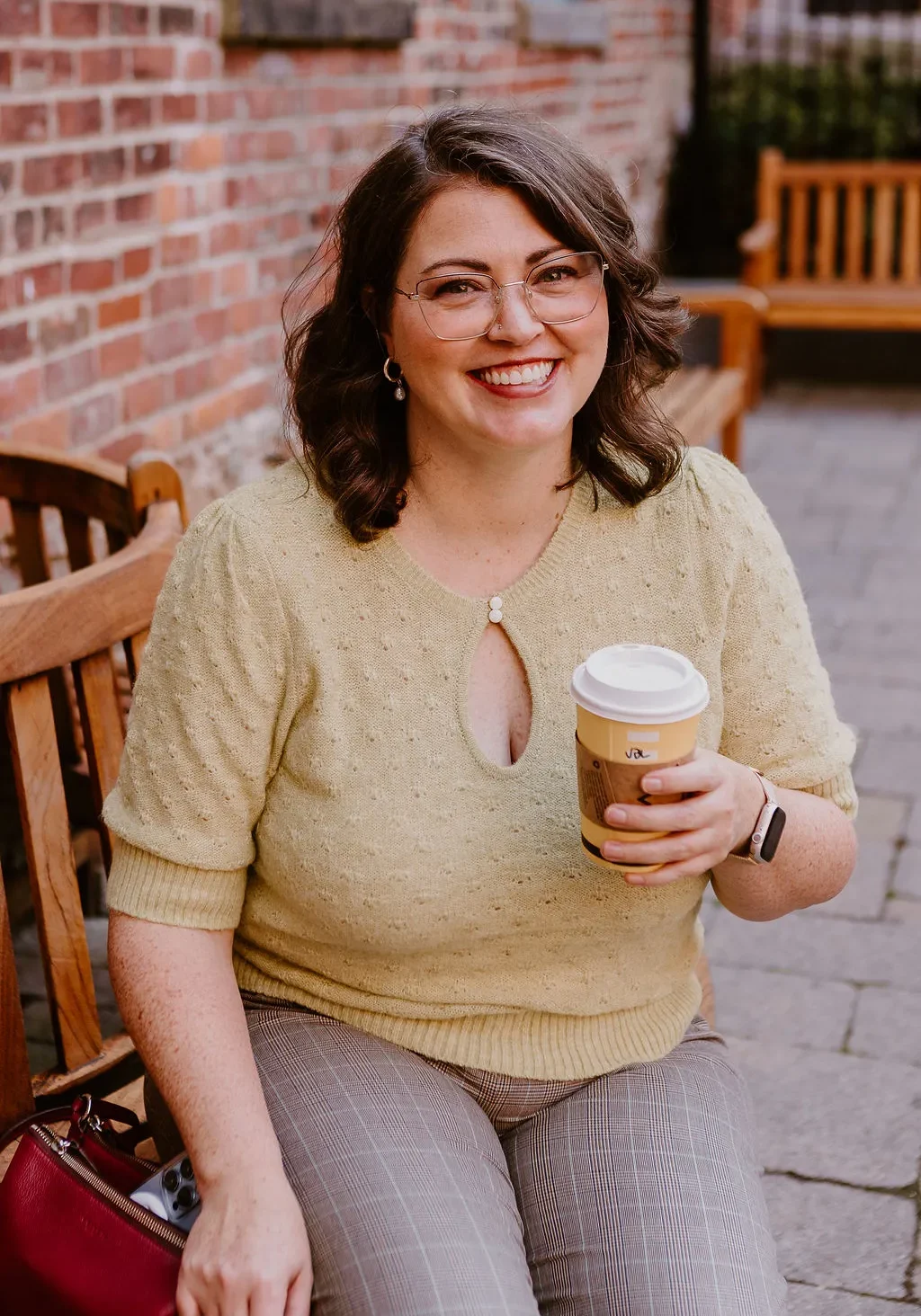 Erica Waddell, founder of Post Road Marketing, smiling outdoors in Saint John NB with a coffee