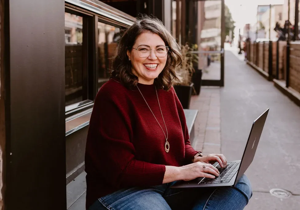 Erica Waddell, founder of Post Road Marketing, working on her laptop outside in downtown Saint John NB