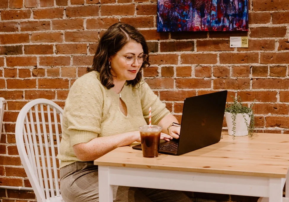 Erica Waddell of Post Road Marketing working on her laptop at a cafe in Saint John NB