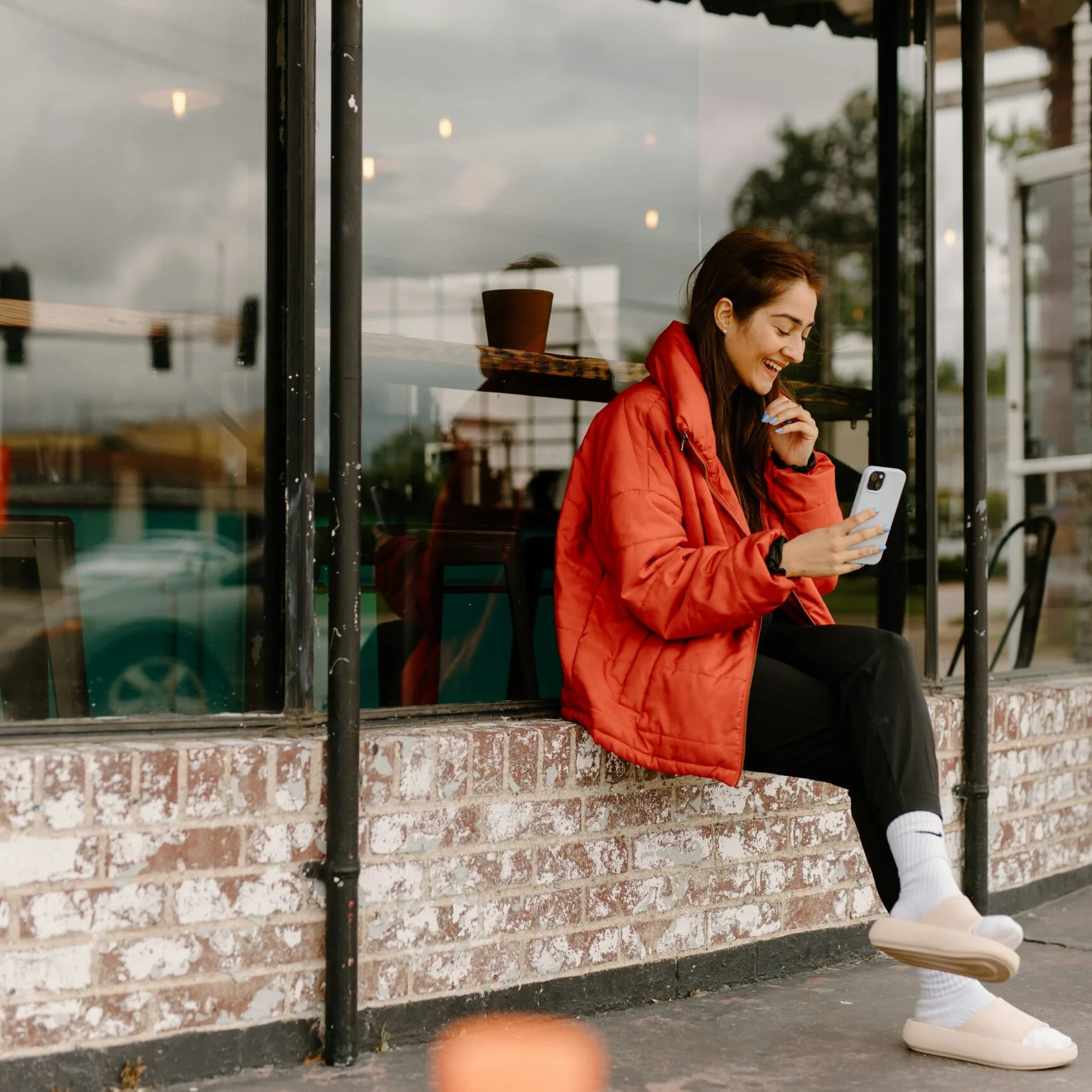Woman checking phone at bus stop — intentional Instagram story content for small business owners